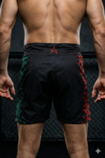 Short de combat Moroccan Punch noir avec lion Atlas et carte du Maroc rouge, porté dans une cage MMA premium, idéal pour Muay Thai, Jiu Jitsu, MMA et CrossFit