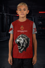 T-shirt enfant Moroccan Punch rouge avec lion Atlas et symboles du Maroc, porté dans une salle MMA premium, vêtement junior idéal pour sports de combat, fitness et lifestyle sportif.