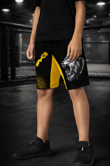 Short enfant Moroccan Punch noir et jaune avec lion Atlas et carte du Maroc, porté dans une cage MMA, tenue junior idéale pour sports de combat, Muay Thai, Jiu Jitsu et CrossFit.