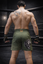 Short MMA Moroccan Punch kaky avec emblème marocain et carte du Maroc, porté par un combattant dans une cage MMA, idéal pour Jiu Jitsu, Muay Thai, CrossFit et sports de combat.